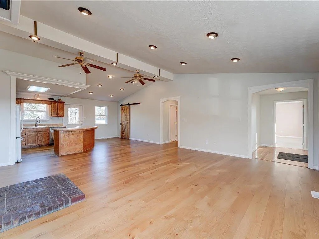 Open-concept living area with wide-plank hardwood flooring and custom barn door